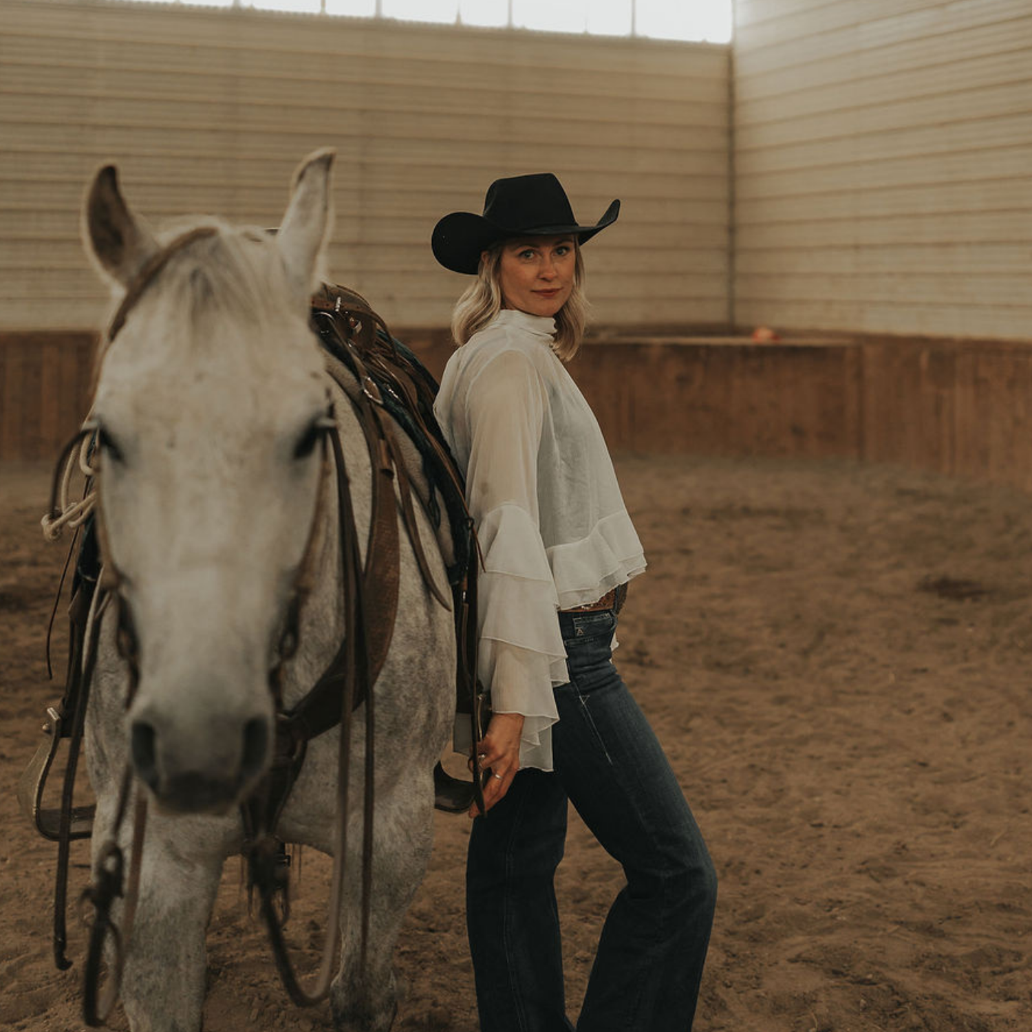 Cowgirl standing beside a horse wearing Prairie Lace perfume by Western Hive, a modern western fragrance inspired by Alberta ranch life